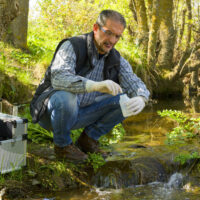 Scientist and biologist hydro-biologist takes water samples for analysis.