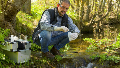 View of a Biologist take a sample in a river.