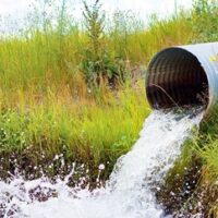 Culvert Spilling Water Splashing out in Grass