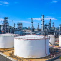 Oil​ refinery​ and​ petrochemical​ architecture plant industrial with blue sky background, White oil and gas refinery tank, Oil refinery plant from industry zone business power and energy petroleum.