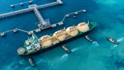 LNG (Liquefied natural gas) tanker anchored in Gas terminal gas tanks for storage. Oil Crude Gas Tanker Ship. LPG at Tanker Bay Petroleum Chemical or Methane freighter export import transportation